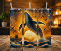 Three tall clear tumblers with metal straws stand on a wooden table, each printed with a dramatic ocean scene featuring a large whale, birds, waves, and a ship under a glowing golden sky.