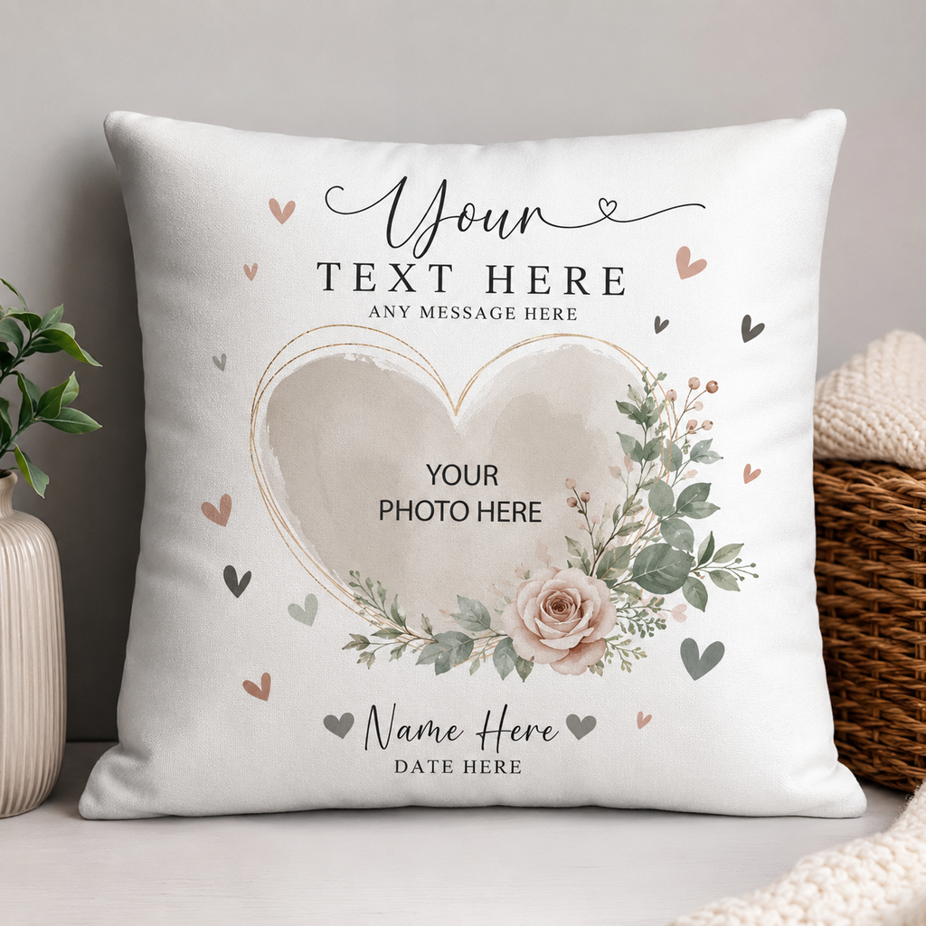 A square white throw pillow with a customizable floral and heart design, styled in a cozy home setting next to a plant and a wicker basket.